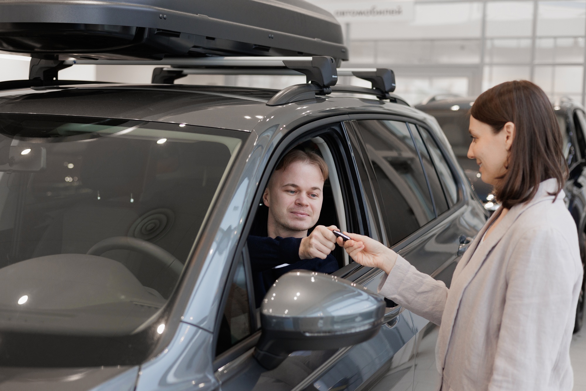 L'homme achète une voiture chez un concessionnaire automobile. 