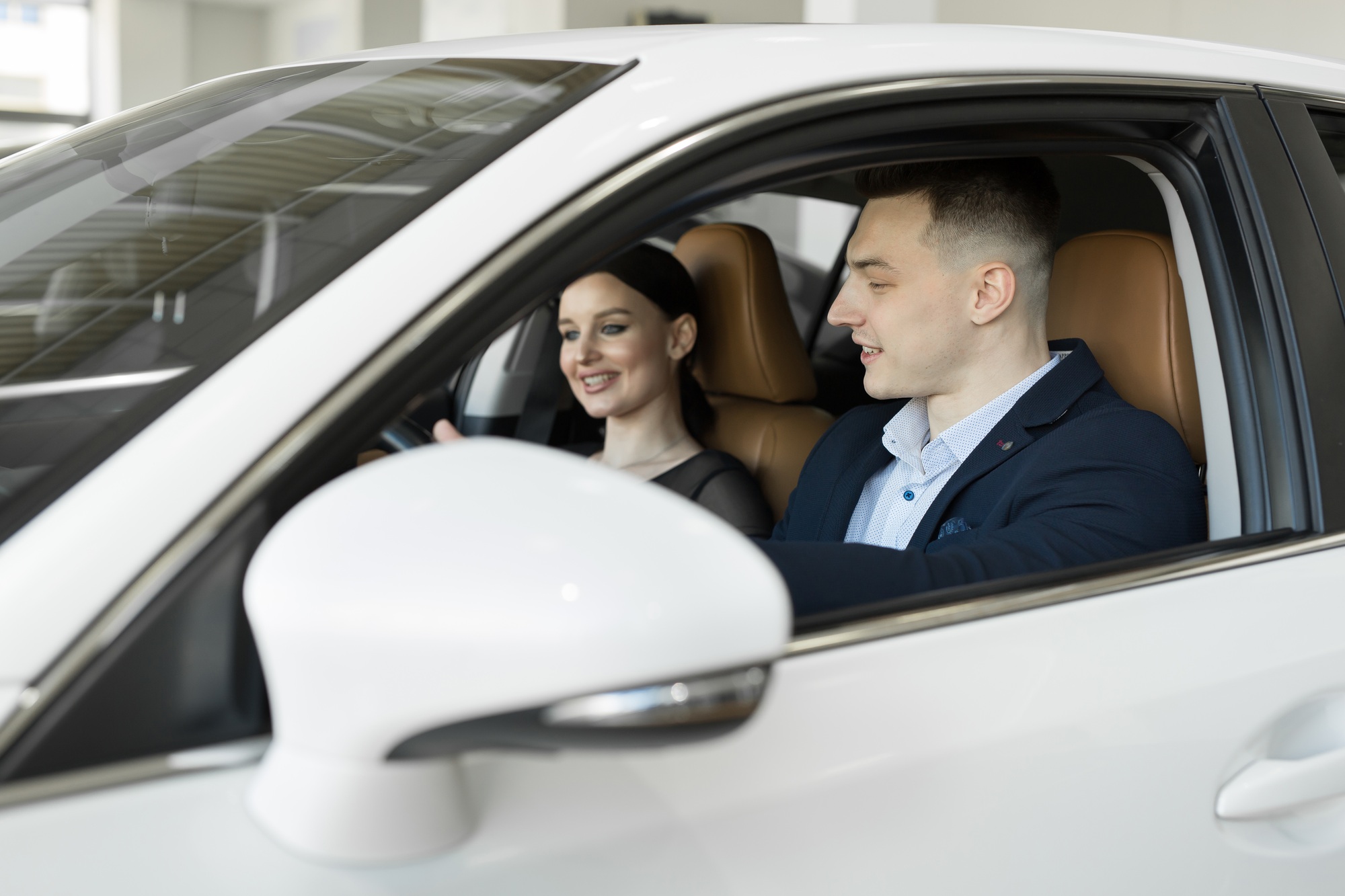 Marié mari et femme assis dans une voiture dans un concessionnaire automobile. 
